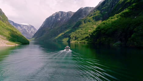 Fahren-Sie-Mit-Einem-Elektroboot-Auf-Norwegischen-Gewässern-In-Einem-Tal,-Das-Von-Grünen-Bergen-Gebildet-Wird