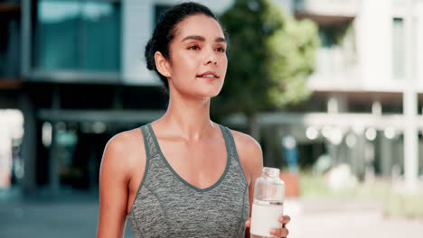 woman hydrating after exercising