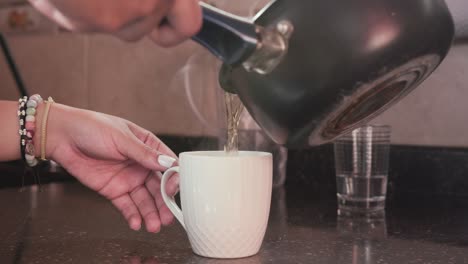 vierta agua caliente en una taza blanca para hacer café o té