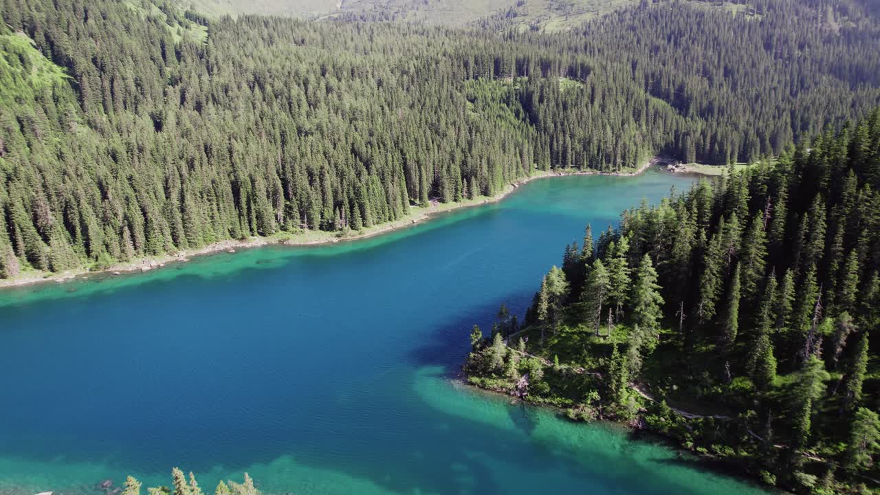 Riprese aeree cinematografiche con drone su uno splendido lago alpino circondato da alberi