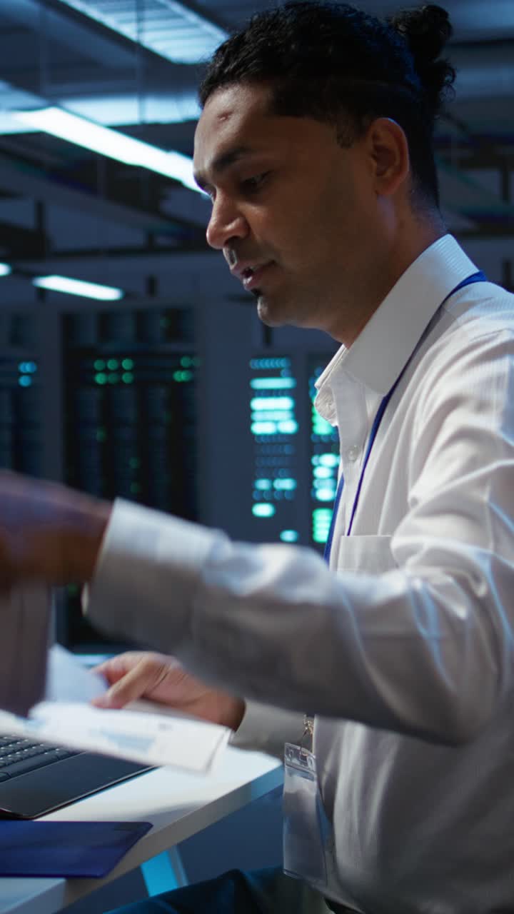Male Programmer Working on Computer in Data Center