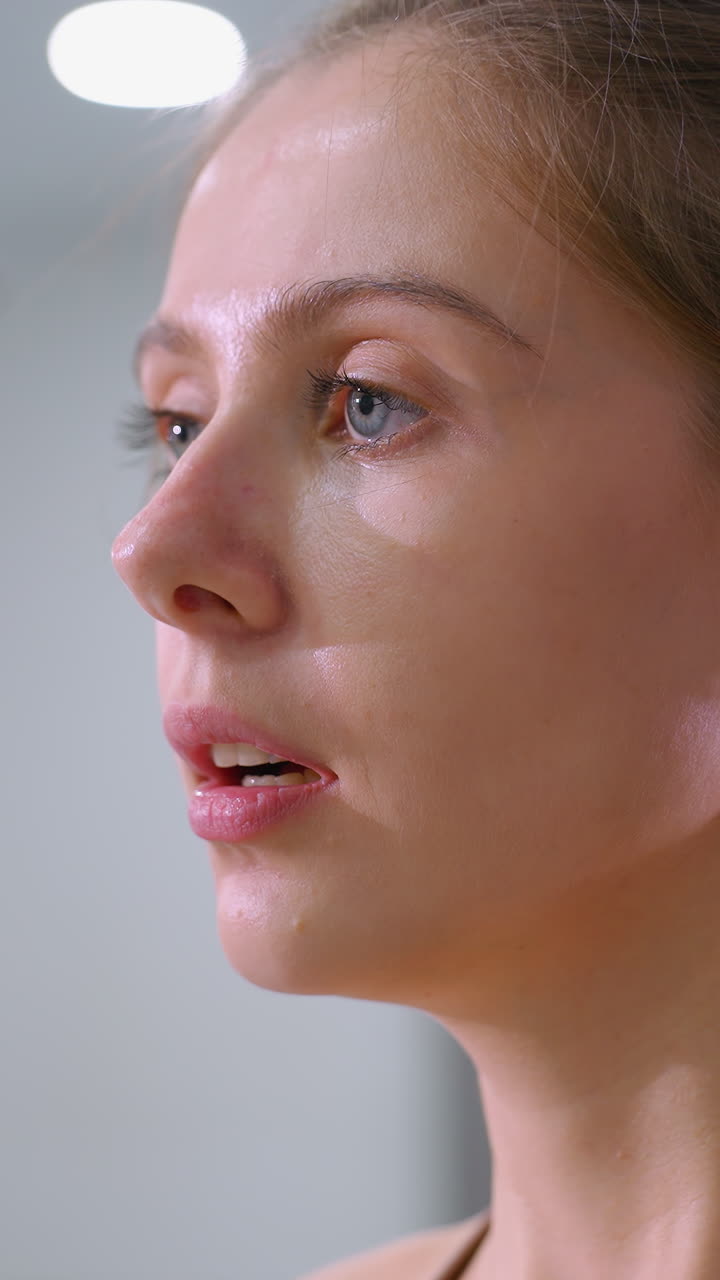 mujer con el cabello de sello marrón atado hacia atrás bebe de una taza de café mientras el espejo refleja su espalda y fondo, momento relajante después del entrenamiento en el gimnasio