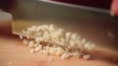 cortar el ajo a mano con un cuchillo en una tabla de cortar