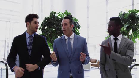 hombres de negocios interactuando entre sí en el vestíbulo de la oficina 4k
