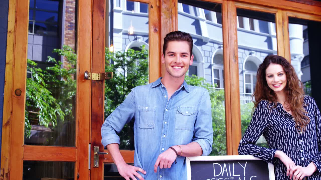 Couple standing at the entrance of caf&Atilde;&copy;