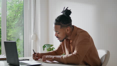 Pondering-businessman-writing-ideas-workplace-closeup.-Involved-man-making-notes