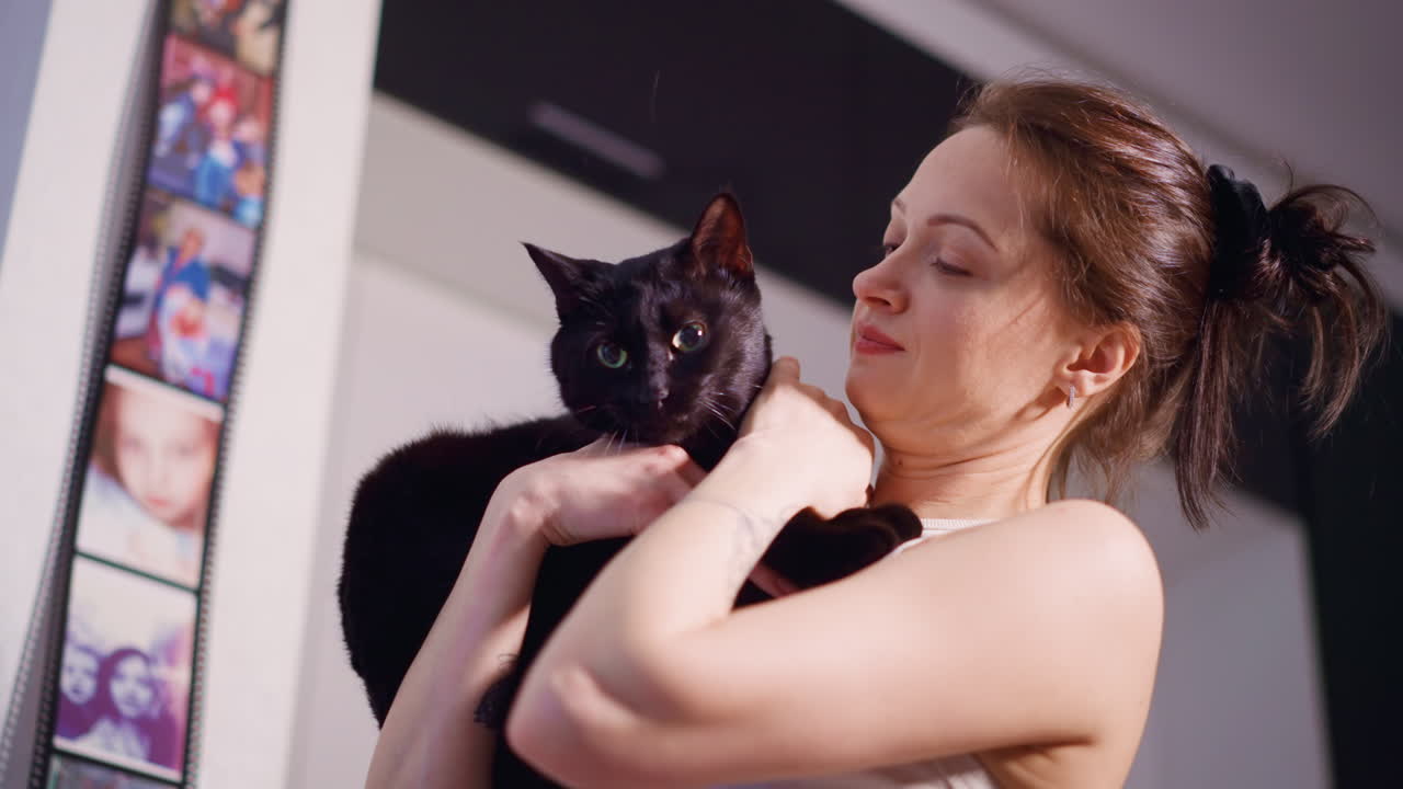 Caucasian Woman Holding Black Cat Playfully Kitchen, Candid Mirror Reflections And Gentle Toss, Joyful Expression, Cozy Apartment Lighting, Pet Sitter Energy And Social Content Vibe