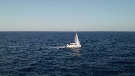 Aerial-view-of-a-luxury-sailboat-passing-by-in-the-middle-of-the-Mediterranean-Sea-near-island-Gozo,-Malta