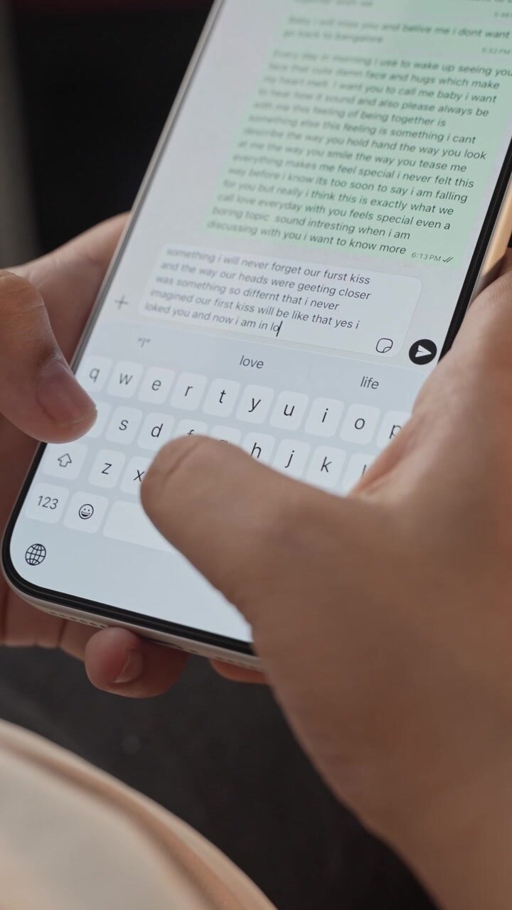 Woman's hand chatting and typing on a smartphone, macro closeup. Unrecognisable human typing a text message, tapping the touchscreen keyboard using the WhatsApp application, a social media.