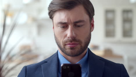 Business-man-chatting-on-smartphone-at-home-office.-Guy-using-cell-phone.