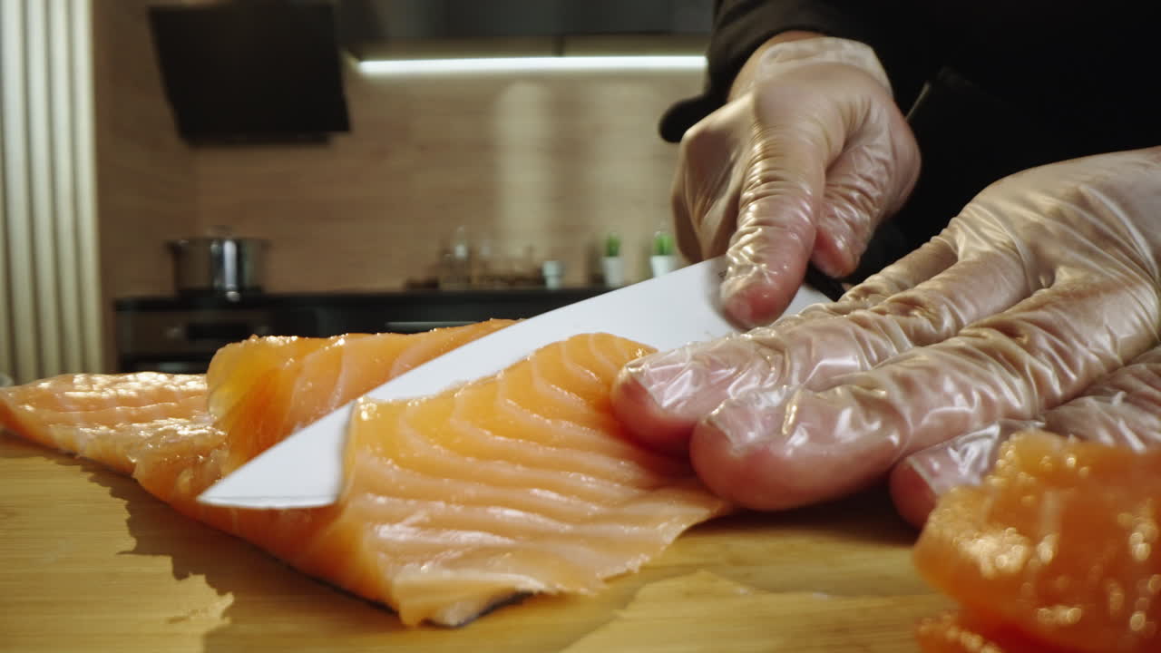 Chef slicing fresh salmon fillet in a kitchen