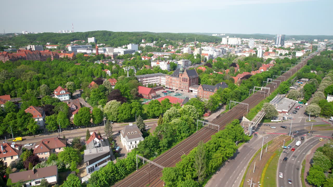 Backward drone overflying the district of Wrzeszcz in Gdansk with a view of the Gdansk University of Technology and the city's transport hubs