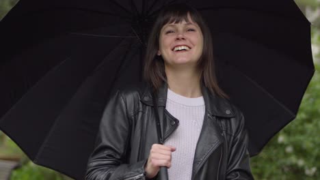 Portrait-of-the-cheerful,-happy-brunette-woman-with-the-black-umbrella