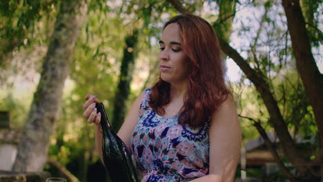 girl-removes-cork-from-wine-bottle-medium-shot