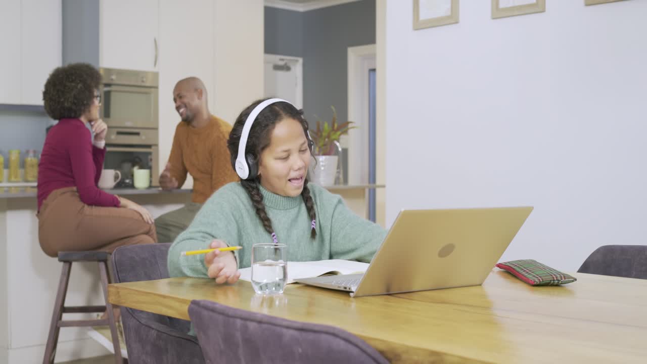 Parents starting conversation, female child typing on laptop waving and writing at home