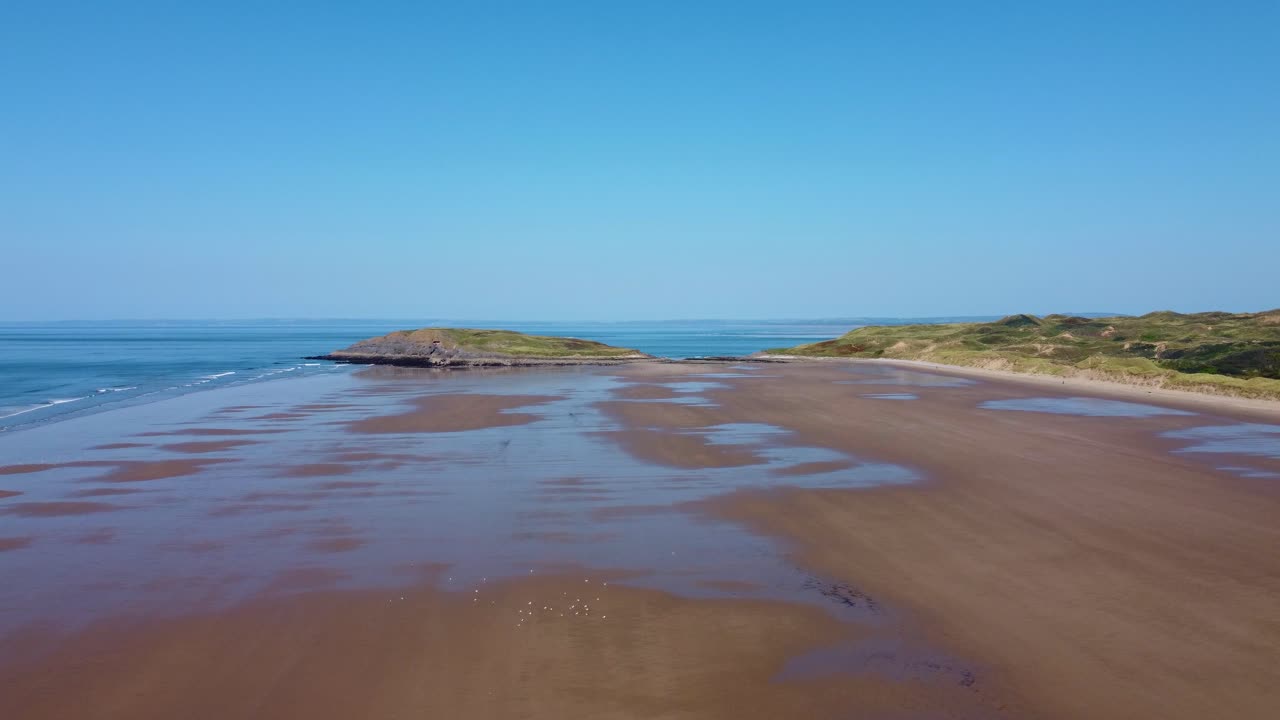 Aerial Drone View of Burry Holms Island Rocks at Low Tide on Rhossili Bay with Sand Dunes 4K