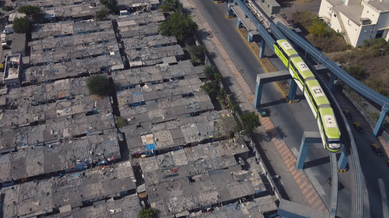 tomada de un avión no tripulado de un monorraíl que pasa por un barrio pobre o una zona subdesarrollada o atrasada.