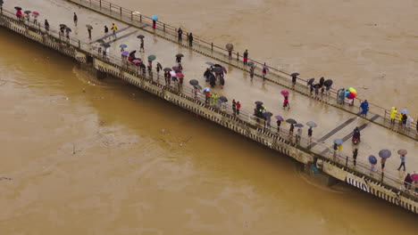 Drone shot of people gathering on Bagmati River bridge to witness rising water levels caused by a cloudburst during monsoon rains scene alarming impact of ongoing climate crisis