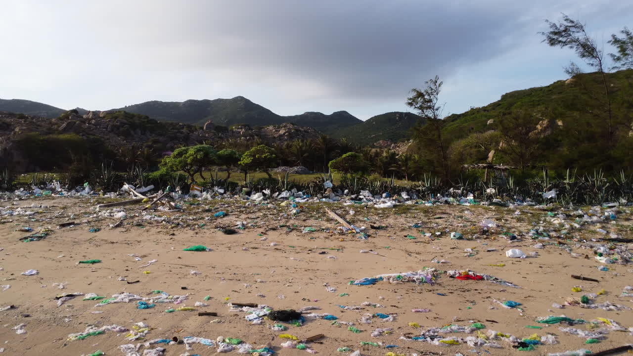 drones vuelan sobre una playa tropical de arena contaminada con residuos plásticos, productos químicos y basura
