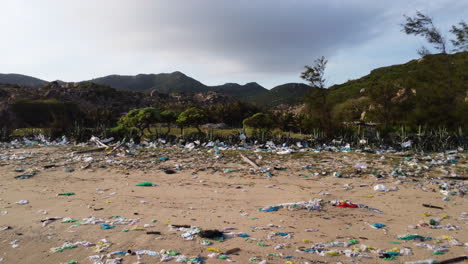 drone fly above sandy tropical polluted beach with plastic waste chemicals and trash