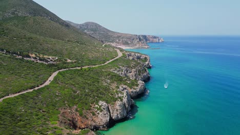 carretera costera a lo largo de acantilados rocosos y mar azul en la costa oeste de cerdeña, italia - antena 4k