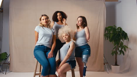 Portrait-Of-Casually-Dressed-Women-Friends-One-With-Prosthetic-Limb-Promoting-Body-Positivity-Studio