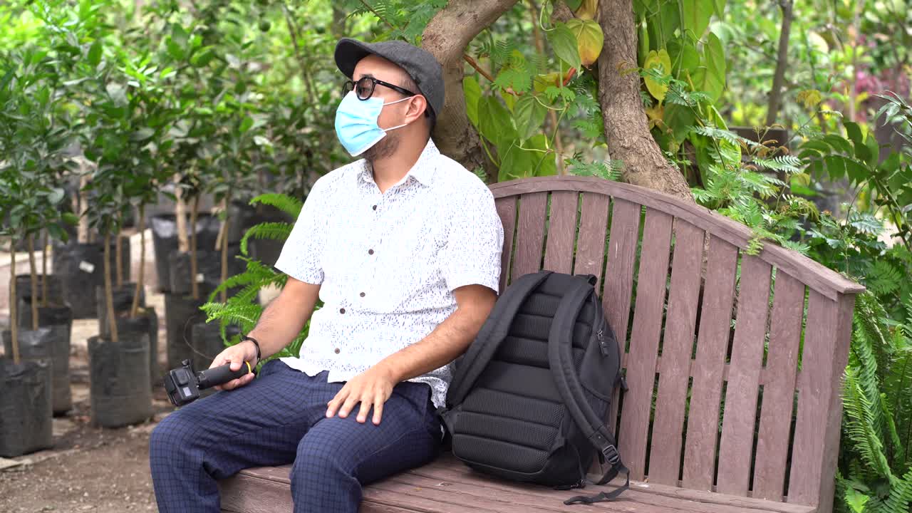Tourist with face mask sitting in bench.