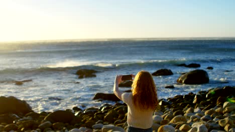 woman taking photo by the shore 4k