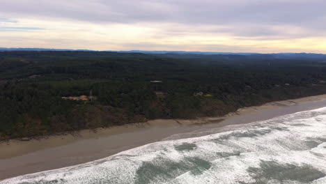 Panoramic-View-Of-Forested-Coastal-Island-With-Foamy-Sea-Waves-Under-Overcast-Sky-In-Bandon,-Oregon