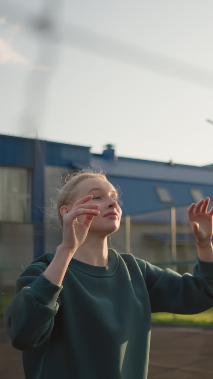 dama con suéter verde jugando al voleibol al aire libre, enfocada y lista para servir o pasar, con el edificio visible en el fondo, capturada en un entorno vibrante con cielos despejados y luz solar