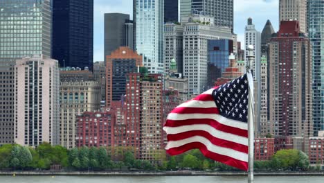 usa flag with new york city skyscrapers in lower manhattan by the battery and hudson river