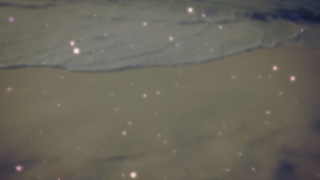 Gentle waves meeting sandy shore, animation of sparkling lights scattered across