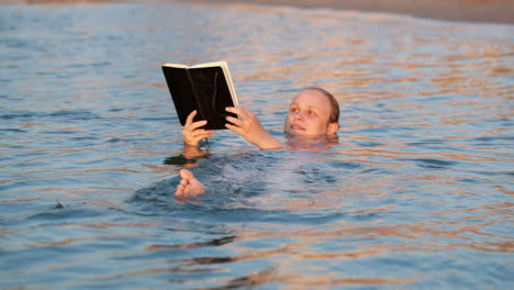 Frau-Lächelt,-Während-Sie-Beim-Schwimmen-Ein-Buch-Liest