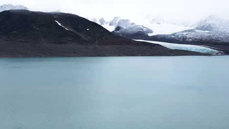 september in the arctic sea in front of a glacier with mountains in the background