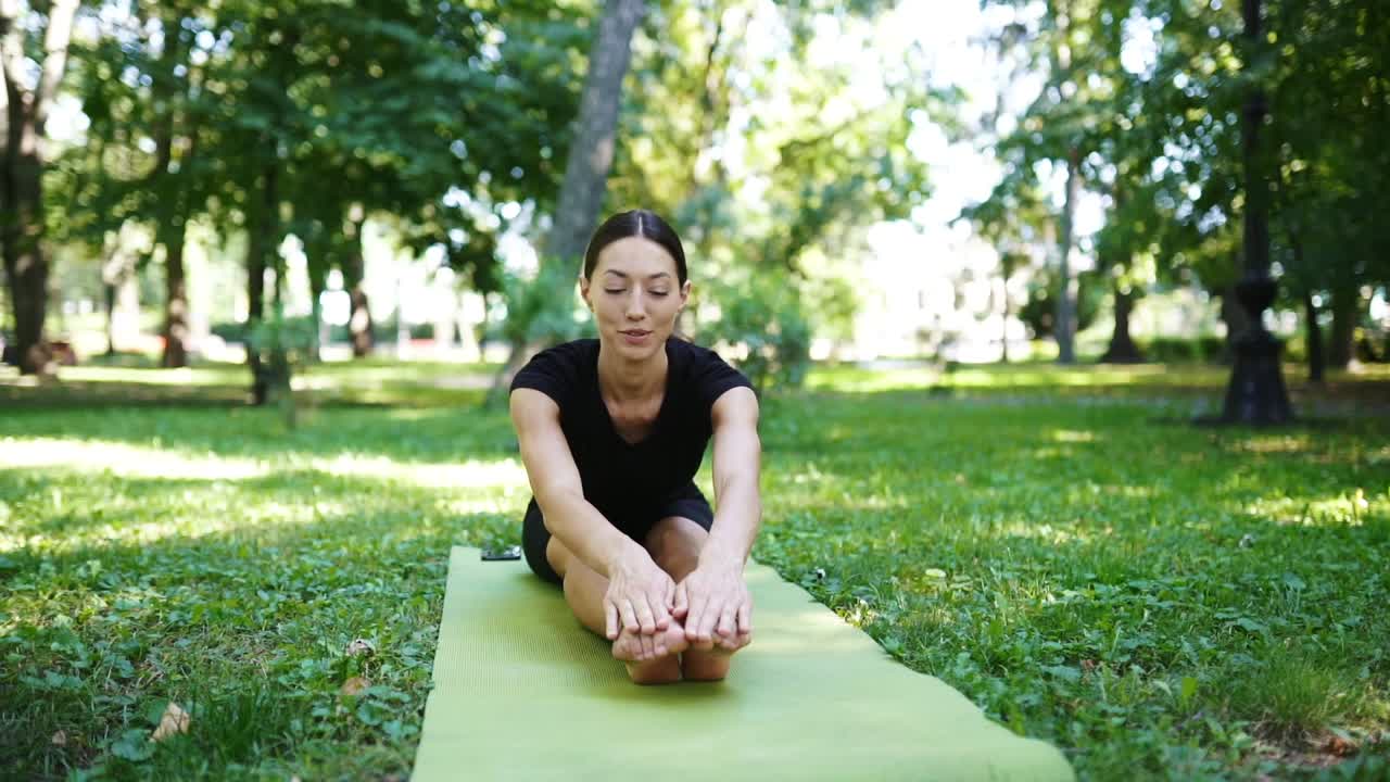 mujer practicando yoga en un parque