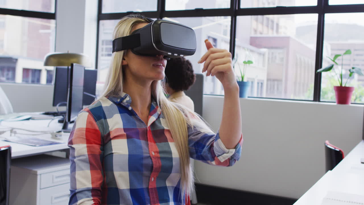 Donna d'affari caucasica seduta e che usa un visore VR in un ufficio moderno