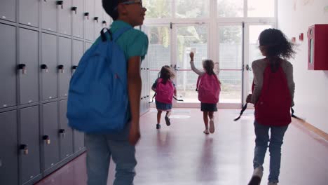 escolares de diferentes edades saliendo de la escuela corriendo para salir de la escuela