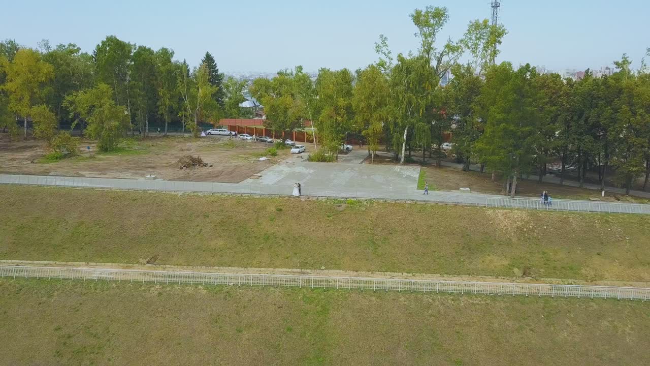 sólo una pareja casada cerca de la barandilla sobre la cascada de la colina aérea