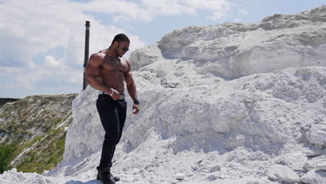 fit young man with beautiful torso. naked torso of african american man posing outdoor