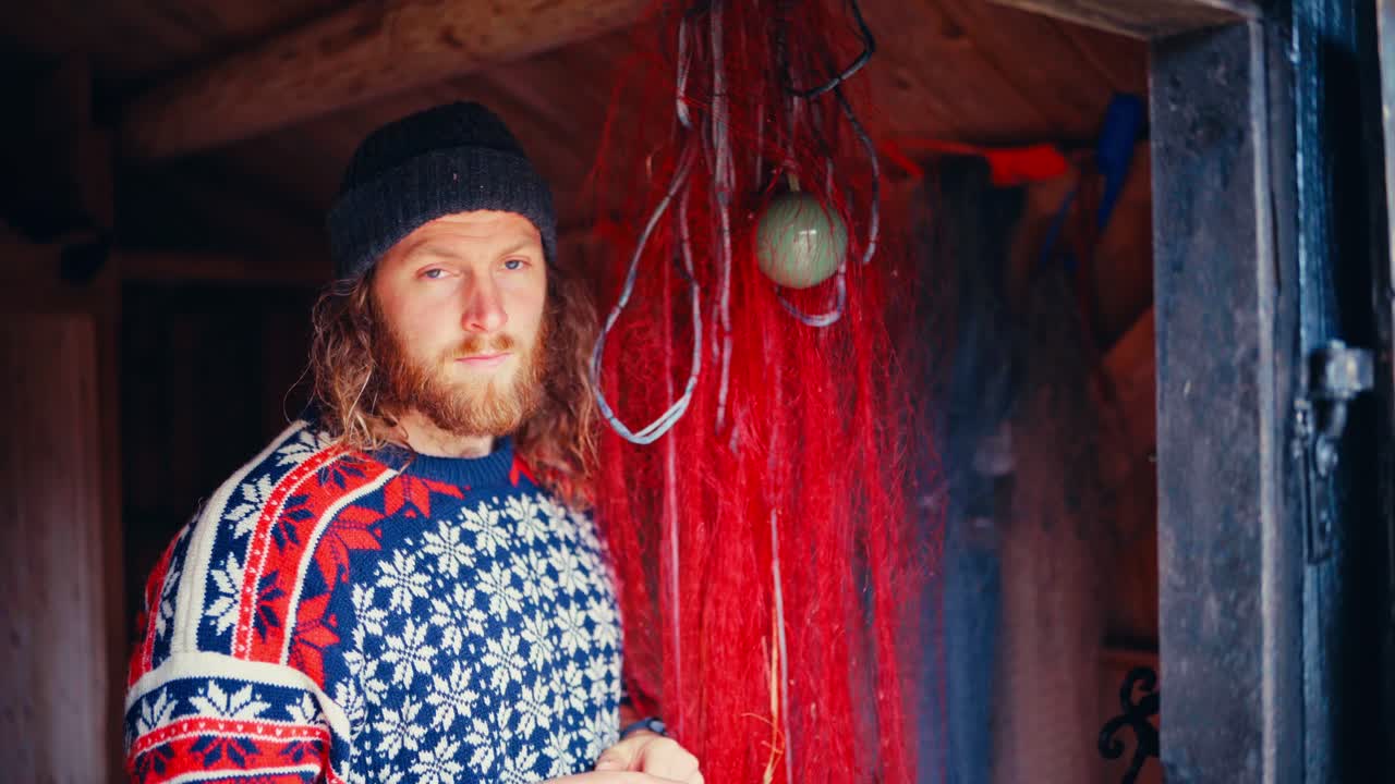 A Man Stands in a Rustic Wooden Hut, Surrounded by Red Fishing Nets in Reinsjøen, Åfjord, Trøndelag, Norway - Close Up