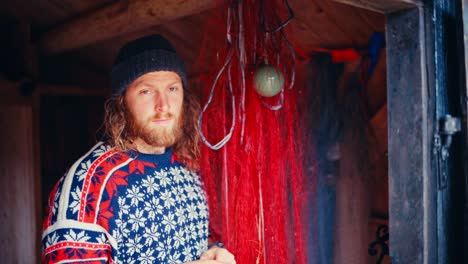 a man stands in a rustic wooden hut, surrounded by red fishing nets in reinsjøen, åfjord, trøndelag, norway - close up