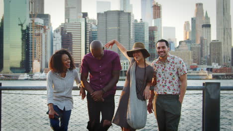 portrait of friends in front of manhattan skyline at sunset