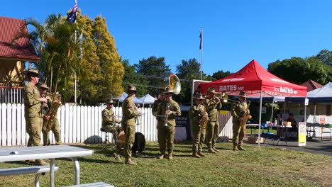 uniformed band plays music at a sunny outdoor fair