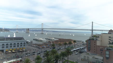 drone flying over san francisco streets toward bay bridge