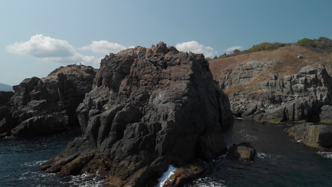 toma aérea de grandes rocas en la orilla del mar en un día soleado de verano
