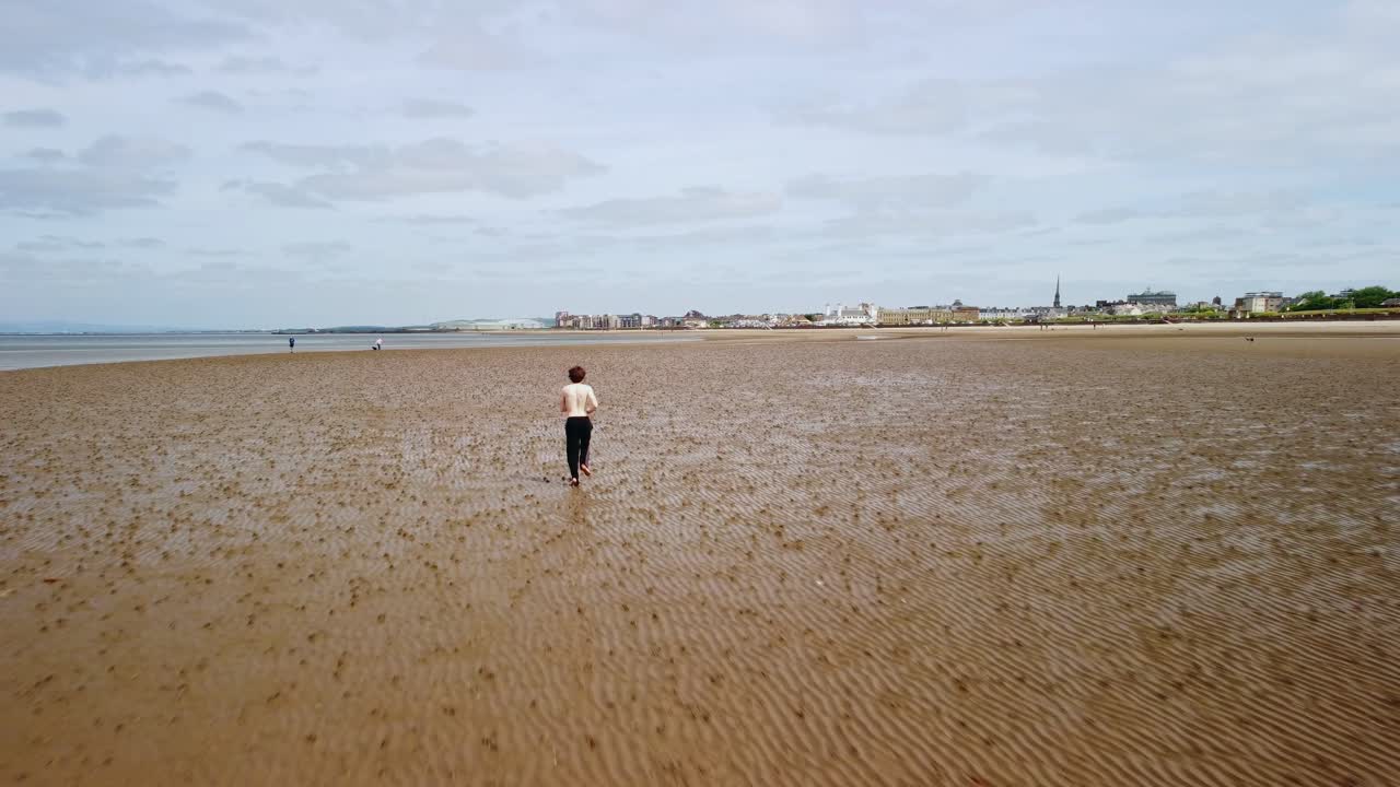 셔츠와 신발 없이 모래 해변에서 달리는 젊은 남자, 안테나