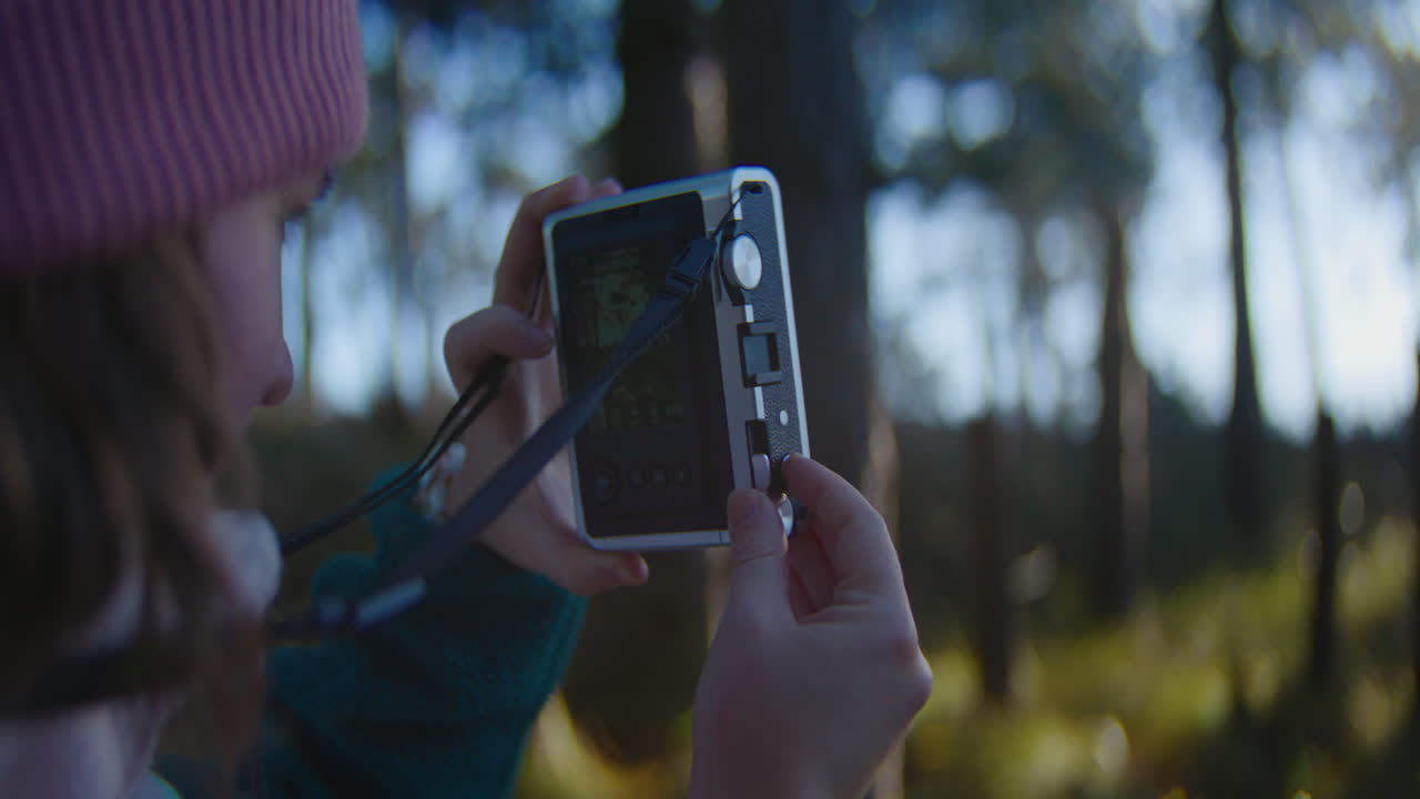 Close up handheld shot of woman taking landscape photos with instant camera