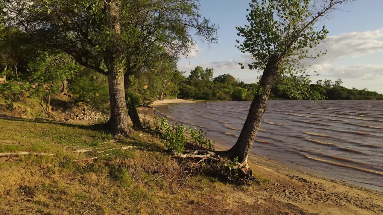 toma aérea hacia atrás de la playa de fray bentos en uruguay con costa verde y sin gente
