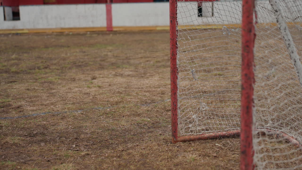 Заброшенная спортплощадка, заброшенная спортивная арена со стареющими футбольными воротами под пасмурным небом, заброшенное спортивное поле со сломанными футбольными воротами на пыльной местности под облачным небом
