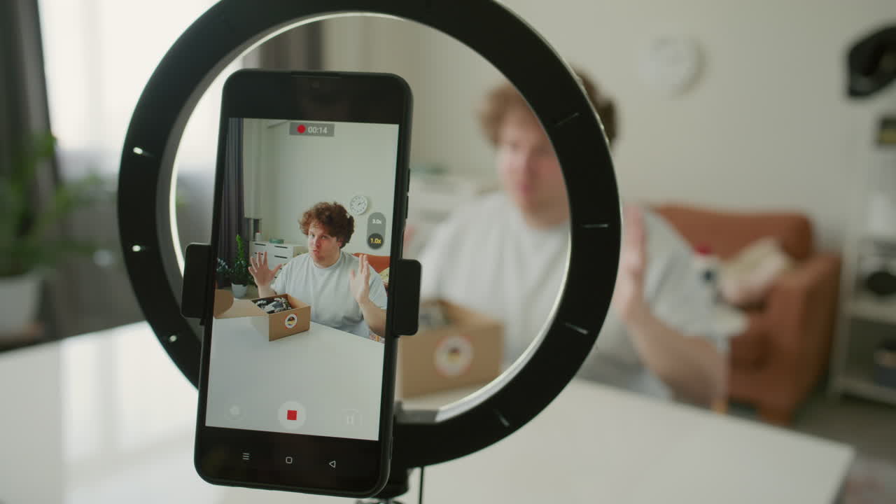 Blogger Unboxing and Reviewing Patterned Shirt on Smartphone Camera